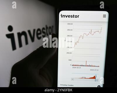 Stuttgart, Deutschland, 19.07.2024: Person, die ein Smartphone hält, mit Webseite der schwedischen Investmentgesellschaft Investor ab vor dem Geschäftslogo. Konzentrieren Sie sich auf c Stockfoto