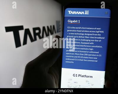 Stuttgart, Deutschland, 28.03.2024: Person, die ein Mobiltelefon hält, mit der Webseite des US-Telekommunikationsunternehmens Tarana Wireless Inc. Vor dem Logo. Konzentrieren Sie sich auf Stockfoto