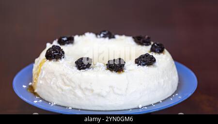 Traditionelles brasilianisches Kokosnuss-Flan-Dessert, bekannt als Manjar branco, Manjar de Coco und Manjar dos deuses. Serviert mit Pflaumensirup. Stockfoto