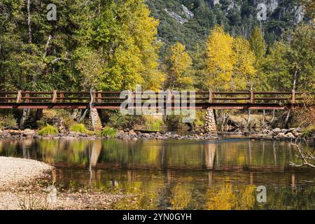 Yosemite Valley Fußgängerbrücke mit Herbstbäumen, die sich im Yosemite National Park spiegeln. Stockfoto