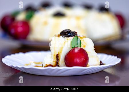 Traditionelles brasilianisches Kokosnuss-Flan-Dessert, bekannt als Manjar branco, Manjar de Coco und Manjar dos deuses. Serviert mit Pflaumensirup. Stockfoto