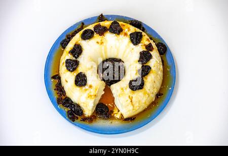 Traditionelles brasilianisches Kokosnuss-Flan-Dessert, bekannt als Manjar branco, Manjar de Coco und Manjar dos deuses. Serviert mit Pflaumensirup. Stockfoto