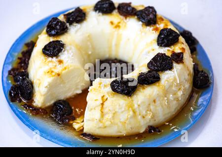 Traditionelles brasilianisches Kokosnuss-Flan-Dessert, bekannt als Manjar branco, Manjar de Coco und Manjar dos deuses. Serviert mit Pflaumensirup. Stockfoto