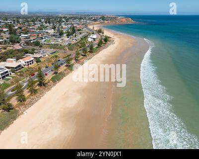 Aus der Vogelperspektive auf sanften Wellen an einem breiten Sandstrand unterhalb einer Küstenstadt am Christies Beach in Adelaide, South Australia Stockfoto