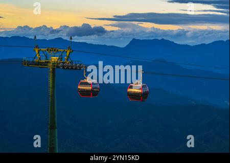 Rote Cabanas einer Seilbahn in den Bergen im Vergnügungspark Ba Na Hills in da Nang in Vietnam bei Sonnenuntergang Stockfoto