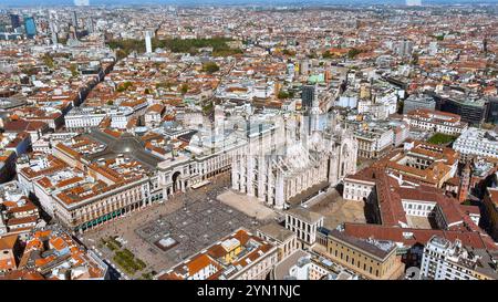 Ein majestätischer Blick aus der Luft auf den Domplatz in Mailand, der das komplizierte gotische Design der Kathedrale inmitten der geschäftigen Stadtlandschaft hervorhebt Stockfoto