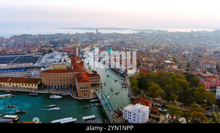 Bezaubernder Blick aus der Vogelperspektive auf den Canal Grande von Venedig bei Sonnenuntergang, mit leuchtenden historischen Gebäuden und lebendigen Wasserstraßen, die das schwindende Licht reflektieren Stockfoto