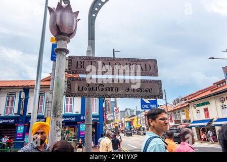 Leute stehen neben einem zweisprachigen zweisprachigen Straßenschild an der Buffalo Road in Little India, Singapur Stockfoto