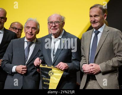 Dortmund, Deutschland. November 2024. Fußball, Bundesliga, Generalversammlung Borussia Dortmund, Westfalenhallen. Wolfgang Paul (M), Vereinslegende und ehemaliger BVB-Spieler, wird von BVB-Präsident Reinhold Lunow (l) und Geschäftsführer Hans-Joachim Watzke als Ehrenkapitän geehrt. Quelle: Bernd Thissen/dpa/Alamy Live News Stockfoto