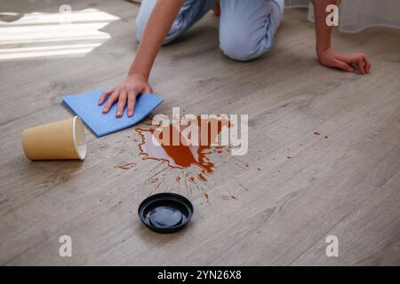 Pappbecher Kaffee fiel auf Laminat, Kaffee verschüttete auf den Boden. Stockfoto