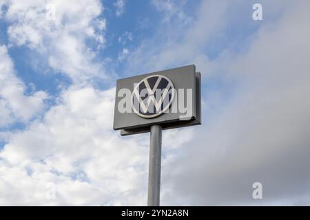 Das Volkswagen-Logo ist auf einem großen Schild vor dem Hintergrund eines bewölkten Himmels deutlich sichtbar Stockfoto