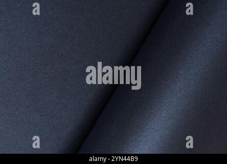Dunkelblauer gerollter Papierhintergrund mit einer glatten, glänzenden Oberfläche. Elegantes und minimalistisches Design mit schlanken Kurven und einem satten, schicken Ton. Perfekt für Mod Stockfoto