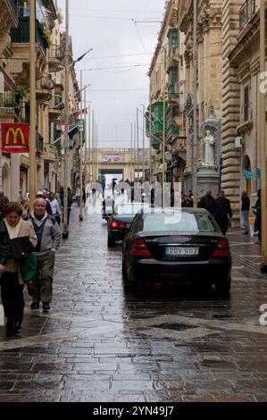 Diplomatische Autos mit Polizeimotorradeskorten auf der regnerischen Straße in Valletta, Malta. Stockfoto