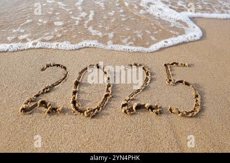 Die Inschrift 2025 auf dem Sand am Meer. Frohes Neues Jahr. Stockfoto