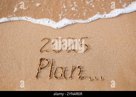 Die Inschrift 2025, Plan auf dem Sand am Meer. Frohes Neues Jahr. Stockfoto