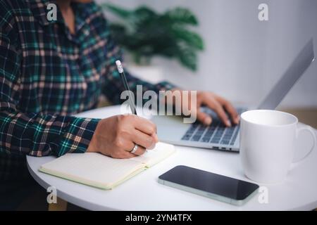 Nahaufnahme Hände von Freelancer benutzen Laptop arbeiten am Schreibtisch von ihr Dies ist ein Lebensstil von Freelancer oder Redakteur. Asiatische Frau, die zu Hause arbeitet oder klein o Stockfoto