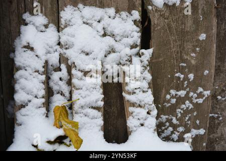 Wunderschönes Winterwetter, frostige Schwelle, Winter, ungewöhnlicher Schnee Hintergrund. Weiße, flauschige Schneeschichten liegen auf Holzbrettern, Holzoberfläche. Stockfoto