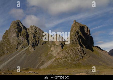 Majestätische isländische Berge ragen über die Landschaft, mit zerklüfteten Gipfeln und lebhaften grünen Tälern, die die atemberaubende natürliche Schönheit Islands zeigen Stockfoto