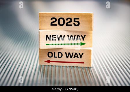 Jahr 2025. Neuer Weg vs. Alter Weg. Konzept, neue Chancen, Entwicklungsrichtung, Ziele für 2025. Geschrieben auf Holzblöcken, wunderschönes, gerilltes Backgro Stockfoto