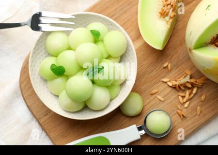 Melonenkugeln in der Schüssel und frisches Obst auf dem Tisch, Blick von oben Stockfoto