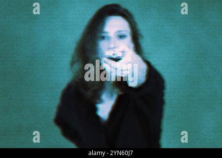 Technologie, Fernsehen und Medienkonzept. Eine junge Frau mit einer Fernbedienung, die nach vorne gerichtet ist. Blauer digitaler Glitcheffekt Stockfoto