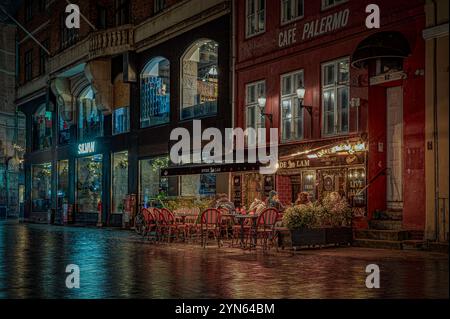 Nachtszene in Kopenhagen Stadt. Leute, die vor einem beleuchteten Restaurant sitzen, Dänemark, 23. November 2024 Stockfoto