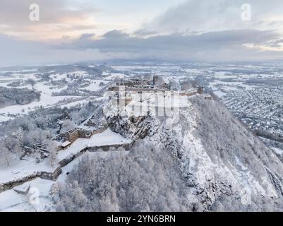 Aus der Vogelperspektive auf den schneebedeckten Hegau-Vulkan Hohentwiel mit Deutschlands größter Burgruine an einem kalten Wintermorgen, vor Sonnenaufgang, umgeben Stockfoto