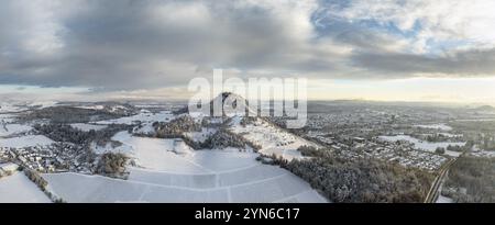 Aus der Vogelperspektive, Panorama des schneebedeckten Hegau-Vulkans Hohentwiel mit Deutschlands größter Burgruine an einem Wintermorgen bei Sonnenaufgang davor Stockfoto