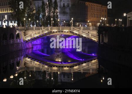 Berühmte drei Brücken auf dem Preseren-Platz im Zentrum von Ljubljana, farbenfroh beleuchtet bei Nacht, Slowenien, Europa Stockfoto