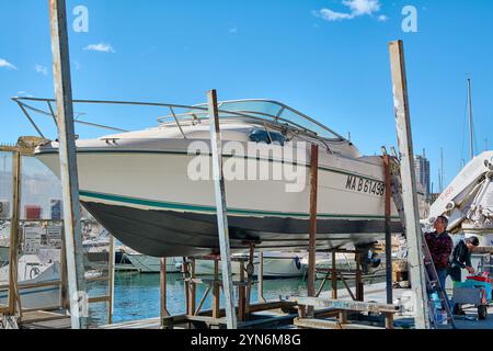 Marseille. Frankreich - 24. November 2024: Marina von Marseille, wo ein Boot namens Le Cap Cara auf einer Stütze stand und von zwei Personen instand gehalten wird. Stockfoto