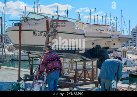 Marseille, Frankreich, 24. November 2024: Hafen von Marseille, in dem Le Cap Cara zur Instandhaltung herangezogen wird. Zwei Leute arbeiten auf dem Schiff, mit zahlreichen Yachten Stockfoto