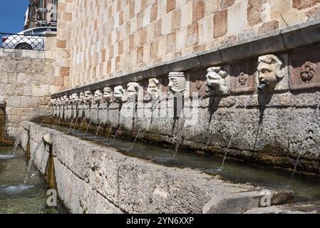 Berühmter mittelalterlicher Brunnen von 99 Ausbrüchen in der Altstadt von L'Aquila, Abruzzi in Italien Stockfoto