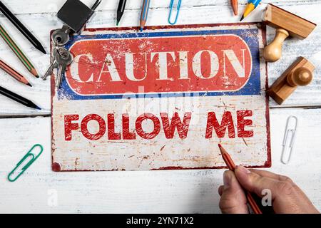 Folge Mir. Warnschild auf dem hölzernen Bürotisch. Stockfoto