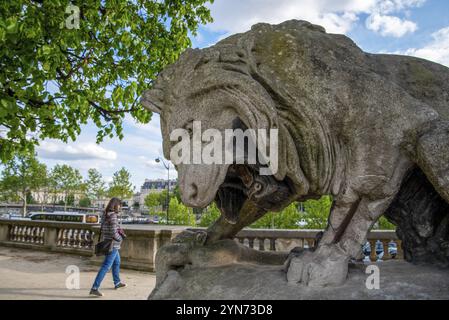 Riesige Löwenskulptur, die auf einen vorbeigehenden Menschen dröhnt, Park des Louvre Palace in Paris, Frankreich, Europa Stockfoto