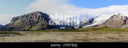 Panoramablick auf einen kleinen Gletscher zwischen Bergen, tief hängende Wolken, Island, Europa Stockfoto