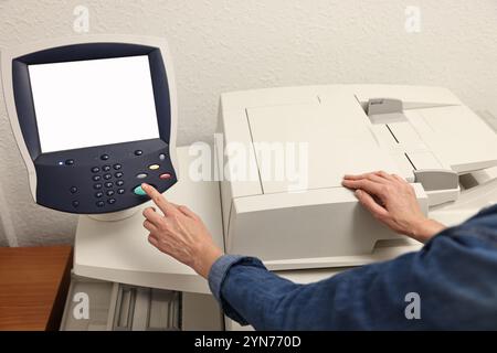 Frau, die drinnen modernen Drucker benutzt, Nahaufnahme. Druckerei Stockfoto