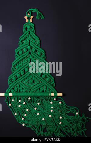 Schöner Weihnachtsbaum aus Makramee auf schwarzem Hintergrund Stockfoto