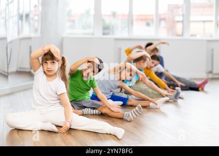 Gruppe von Kindern, die sich vor dem Tanzkurs aufwärmen Stockfoto