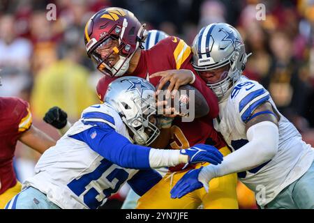 Landover, MD, USA. November 2024. Washington Commanders Quarterback Jayden Daniels (5) wird von den Dallas Cowboys Linebacker DeMarvion Overshown (13) und Defensive End Chauncey Golston (99) während des NFL-Spiels zwischen den Dallas Cowboys und den Washington Commanders in Landover, MD Reggie Hildred/CSM (Credit Image: © Reggie Hildred/Cal Sport Media) entlassen. Quelle: csm/Alamy Live News Stockfoto