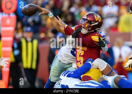 Landover, MD, USA. November 2024. Washington Commanders Quarterback Jayden Daniels (5) wird von den Dallas Cowboys Linebacker DeMarvion Overshown (13) und Defensive End Chauncey Golston (99) während des NFL-Spiels zwischen den Dallas Cowboys und den Washington Commanders in Landover, MD Reggie Hildred/CSM/Alamy Live News, entlassen Stockfoto