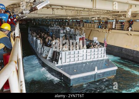 US-Marines und Seeleute, die der Bravo Company, dem Battalion Landing Team 1/5, 15. Marine Expeditionary Unit, zugewiesen sind, bereiten sich darauf vor, das amphibische Angriffsschiff USS Boxer (LHD 4) an Bord eines Landungsbootes zu verlassen, das der Angriffsbooteinheit 1 im Pazifischen Ozean am 23. November 2024 angehört. Teile der 15. MEU sind derzeit an Bord der Boxer angelaufen und führen Routineeinsätze in der 3. US-Flotte durch. (Foto des U.S. Marine Corps von CPL. Joseph Helms) Stockfoto