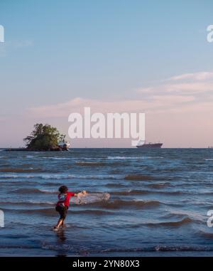 Ein Fischer wirft ein Netz am Strand von Balikpapan, Ostkalimantan, Indonesien Stockfoto