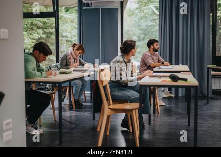 Schüler hören im Unterricht aufmerksam auf ältere Professoren zu Stockfoto