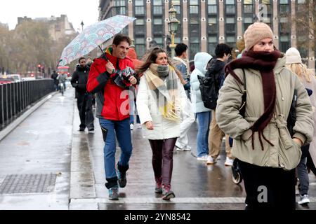 London, Großbritannien. November 2024. Die Leute laufen auf der Westminster Bridge in London, Großbritannien, 23. November 2024. Starke Winde, starker Regen und Überschwemmungen durch Sturm Bert verursachten Reiseverluste und Stromausfälle in ganz Großbritannien am Wochenende, wodurch drei Männer starben. Quelle: Xinhua/Alamy Live News Stockfoto