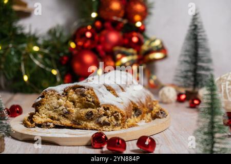 Traditioneller deutscher Weihnachtsstollenkuchen im Hintergrund mit handgemachter festlicher Dekoration. Winterferien. Zubereitung veganer Backrezepte Stockfoto