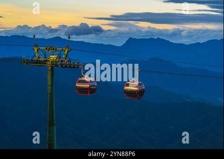 Rote Cabanas einer Seilbahn in den Bergen im Vergnügungspark Ba Na Hills in da Nang in Vietnam bei Sonnenuntergang Stockfoto