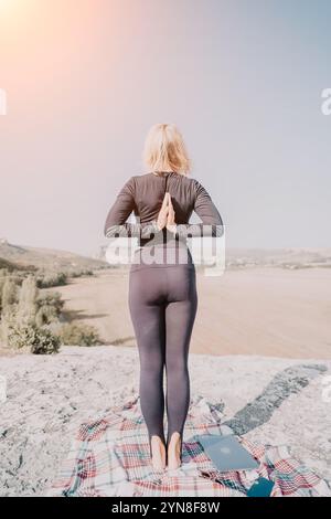 Frau, die Yoga auf einem Berggipfel praktiziert Stockfoto