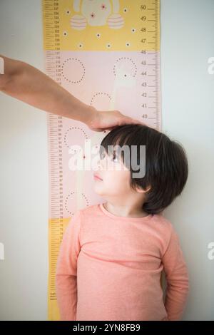 Junge, der auf Größe gemessen wird Stockfoto