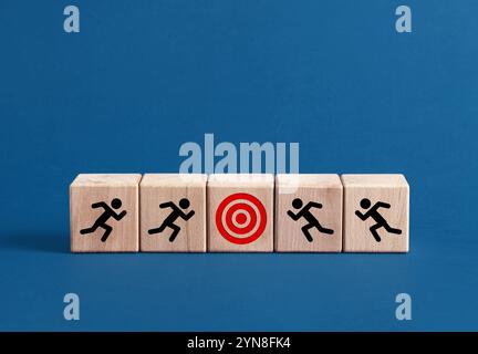 Geschäftsmänner-Symbole, die auf Holzblöcken zu roten Zielen laufen, zeigen das Erreichen von Geschäftszielen und -Zielen Stockfoto