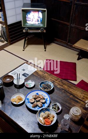 Wohneinrichtung aus der Showa-Zeit um 1950 bis 1960 mit Tatami-Mattenboden, Schiebetüren und niedrigem Esstisch mit Zabuton-Kissen. Stockfoto